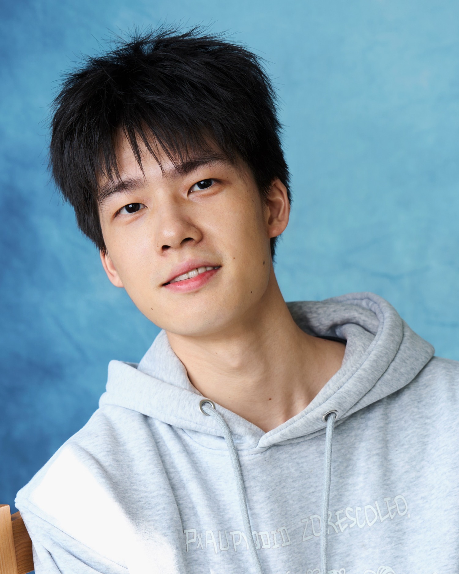 Fred in a grey hoodie with head gently tilted